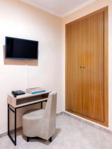 a desk with a chair and a television on a wall at Hostal Antigua Morellana in Valencia +28 photos