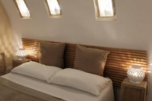 a bedroom with a bed with two pillows and two lights at Bari Vecchia Suite in Bari