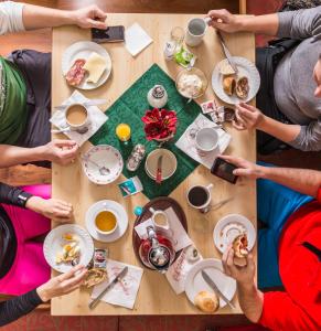 un grupo de personas sentadas alrededor de una mesa comiendo comida en Apart-Pension Oberreiter, en Fusch an der Glocknerstrasse