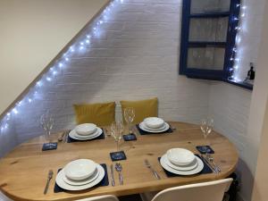 a wooden table with chairs and plates and wine glasses at Witcroft Cottage in Pershore +30 photos