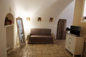 Una sala de estar con una silla y un espejo. en Bari Vecchia Suite, en Bari