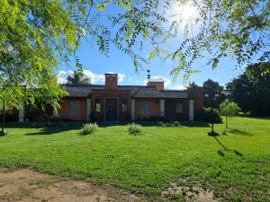 una gran casa de ladrillo con un patio de hierba en QUINTA LA ESTELA, en Pilar