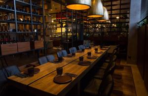 einen langen Holztisch in einem Restaurant mit Stühlen in der Unterkunft Hotel Berlin Potsdamer Platz by Leonardo Hotels in Berlin + 28 Fotos