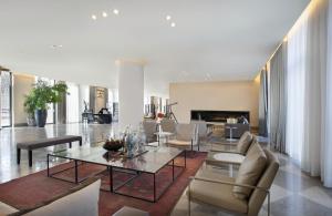 ein Wohnzimmer mit einem Glastisch und Stühlen in der Unterkunft Hotel Berlin Potsdamer Platz by Leonardo Hotels in Berlin