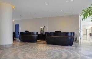 eine Lobby mit zwei Stühlen in einem Gebäude in der Unterkunft Hotel Berlin Potsdamer Platz by Leonardo Hotels in Berlin