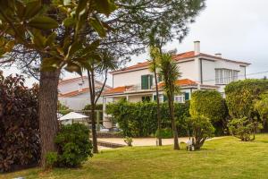 a large white house with palm trees in a yard at Casa Barão das Laranjeiras in Ponta Delgada