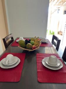 a table with red napkins and a bowl of fruit at Martuno house in Fernando de Noronha