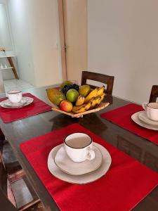 a table with a bowl of fruit and a cup of coffee at Martuno house in Fernando de Noronha
