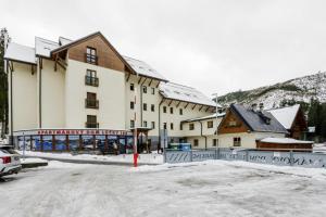 a large building with snow on the ground at Apartmán Orech in Belá