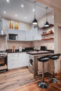 a kitchen with white cabinets and a dishwasher at Retro Nutshell! in Cairo +26 photos