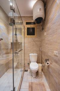 a bathroom with a toilet and a glass shower at Retro Nutshell! in Cairo