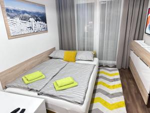 a small bedroom with a bed with yellow pillows at Apartmán Orech in Belá