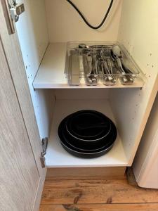 a cabinet with a stack of plates and pots and pans at Studio au château de Lachau in Lachau +2 photos