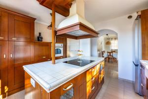 Una cocina con gabinetes de madera y un horno de estufa. en Villa Calma Private Pool La Oliva By Holidays Home, en La Oliva