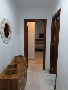 Habitación con tocador de madera y espejo. en Apartamento Al Sur del Sur, en Sanlúcar de Barrameda