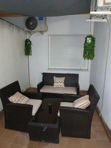 Una pequeña sala de estar con dos sillas y un sofá. en Apartamento Al Sur del Sur, en Sanlúcar de Barrameda