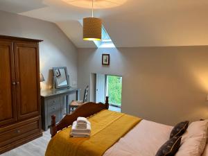 a bedroom with a bed and a desk and a window at Aldernaig Mill in Invergarry