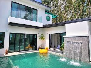 a house with a swimming pool in front of it at Villa Coco - Tropical Paradise with Private Pool in Thalang