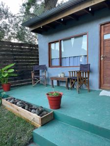 Un patio con dos sillas y una mesa y un banco. en Habitación para 2 personas, en Valeria del Mar