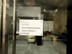 a sign in a window with a game room and lounge at Big screen cinema tv, 5 queen bed Luxury apt 2cp in Jelutong
