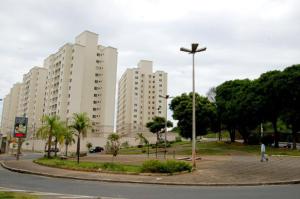 a person walking in a park with tall buildings at Apartamento aconchegante e bem localizado in Belo Horizonte