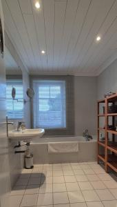 un bagno bianco con lavandino, vasca e lavandino di 269 Bel Ebat a Le Bois-Plage-en-Ré Altre 6 foto