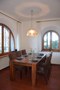 a dining room table with chairs and a chandelier at Villa Casa Camelia in Traumlage in San Bartolomeo
