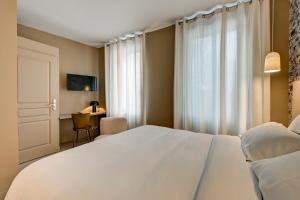Postel nebo postele na pokoji v ubytování Hôtel Bellegarde by Viktor