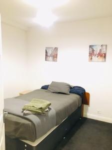 a bed in a room with two pictures on the wall at Hagley Road West House in Birmingham +14 photos