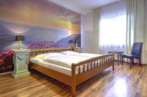 a bedroom with a bed and a painting on the wall at Privathotel Stickdorn in Bad Oeynhausen