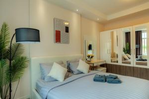 a bedroom with a bed with two pairs of shoes on it at Stylish room Near Central Fest in Chiang Mai