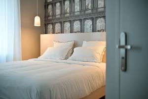 Postel nebo postele na pokoji v ubytování Hôtel Bellegarde by Viktor