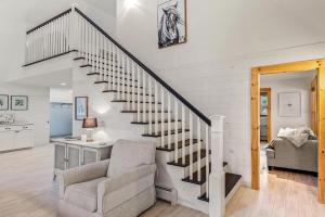 a living room with a staircase and a chair at Fellows Maine Home, A Coastal Retreat Near Acadia in Surry