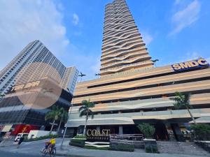 a person riding a bike in front of a building at La Chicka Staycation in Coast Residences in Manila