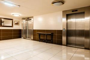 a hallway with a elevator and a table on the wall at Muthu Glasgow River Hotel in Erskine
