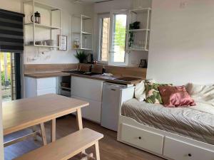 a kitchen and a living room with a couch and a table at Maisonnette Individuelle in Carpiquet