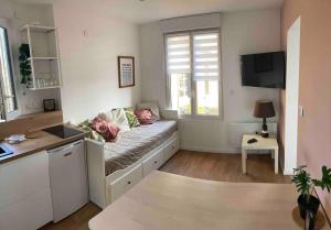 a living room with a couch and a window at Maisonnette Individuelle in Carpiquet