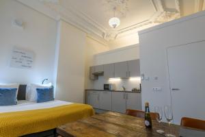 a room with a bed and a table and a kitchen at Oranjestaete Boutique Hotel & Apartments in Nijmegen