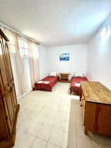 a room with two beds and a table in it at Family-Friendly Studio in Mahdia
