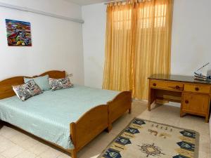 a bedroom with a wooden bed and a desk at Family-Friendly Studio in Mahdia
