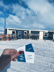 a person holding a card in front of a ski lodge at Apartman KIKI in Kupres