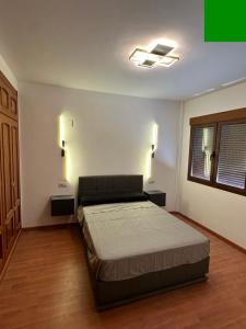 a bedroom with a bed and two lights on the wall at VillaLuxury in Dúrcal