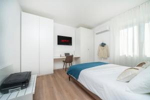 Un dormitorio con una cama y un escritorio con televisión. en Oberdan 5 Centro Storico - A Casa Tua, en Pordenone