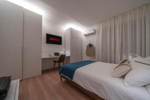 Dormitorio con cama y escritorio con monitor en Oberdan 5 Centro Storico - A Casa Tua, en Pordenone
