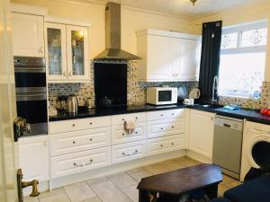 a kitchen with white cabinets and a microwave at Goldicroft House Road in Wednesbury