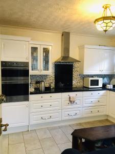a kitchen with white cabinets and a stove top oven at Goldicroft House Road in Wednesbury