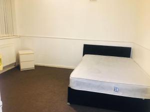 a small bedroom with a bed and a night stand at Goldicroft House Road in Wednesbury