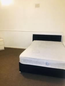 a bed in a room with a white mattress at Goldicroft House Road in Wednesbury +2 photos