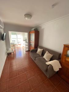ein Wohnzimmer mit einer Couch auf einem Fliesenboden in der Unterkunft Casa Ana Maro in Maro