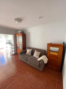 ein Wohnzimmer mit Sofa und Fliesenboden in der Unterkunft Casa Ana Maro in Maro